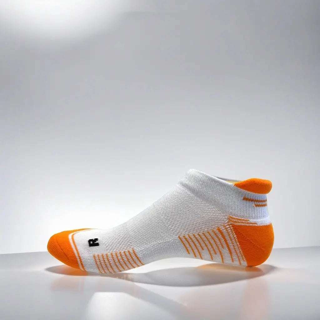 Low cut white and orange running socks with arch support and ventilation
